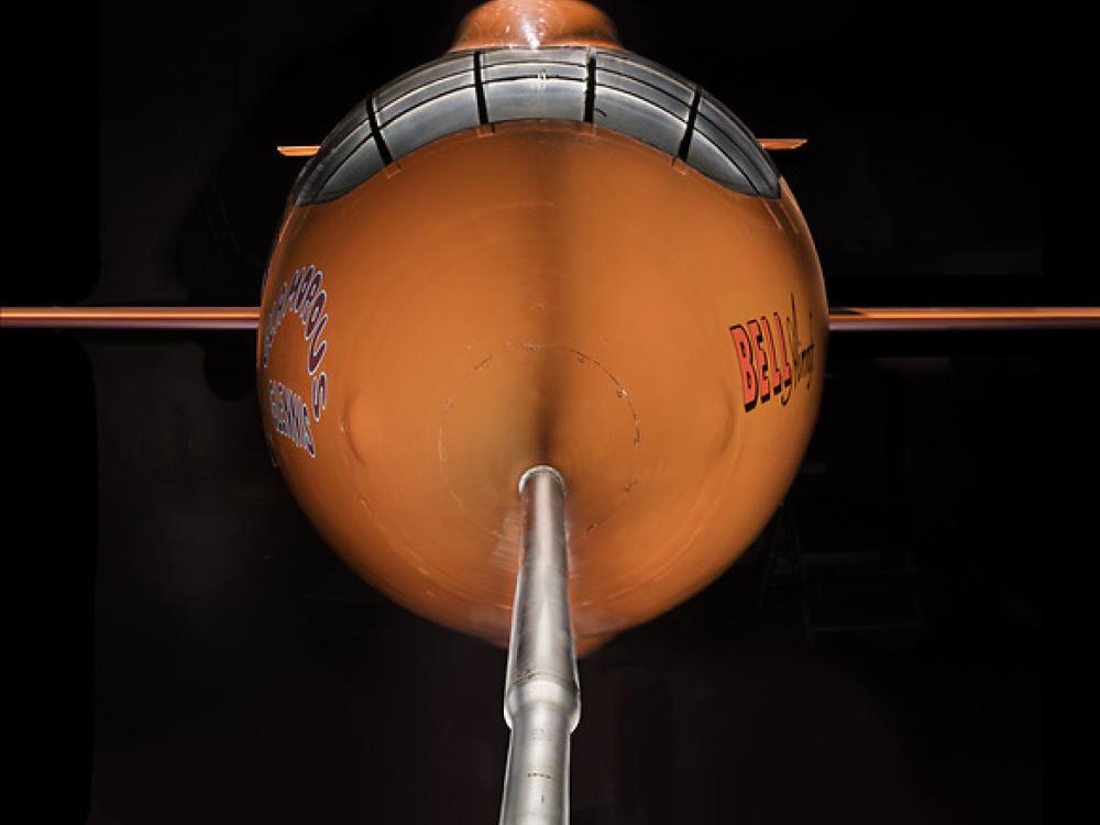 Front view of nose of an aircraft. The aircraft is painted orange. 