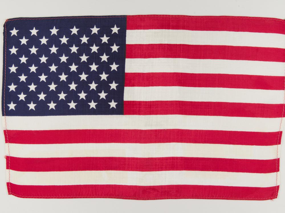 American flag unfolded against white backdrop.