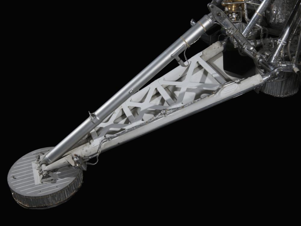 Metal foot pad attached to triangular space frame leg.