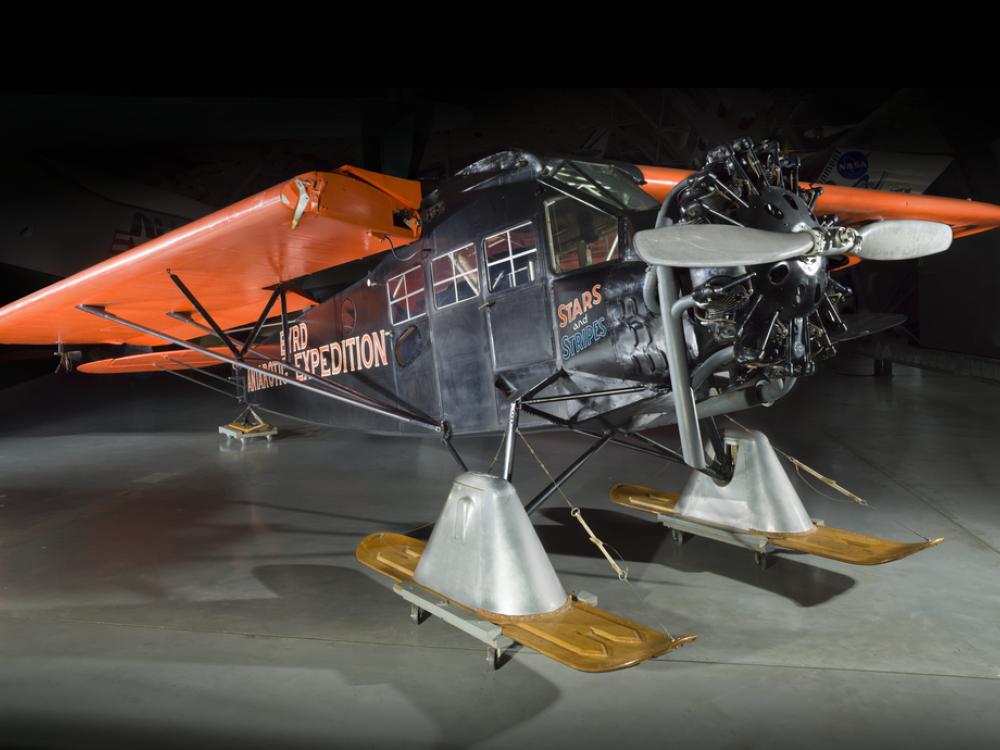 Black and orange painted plane with landing skis. 		