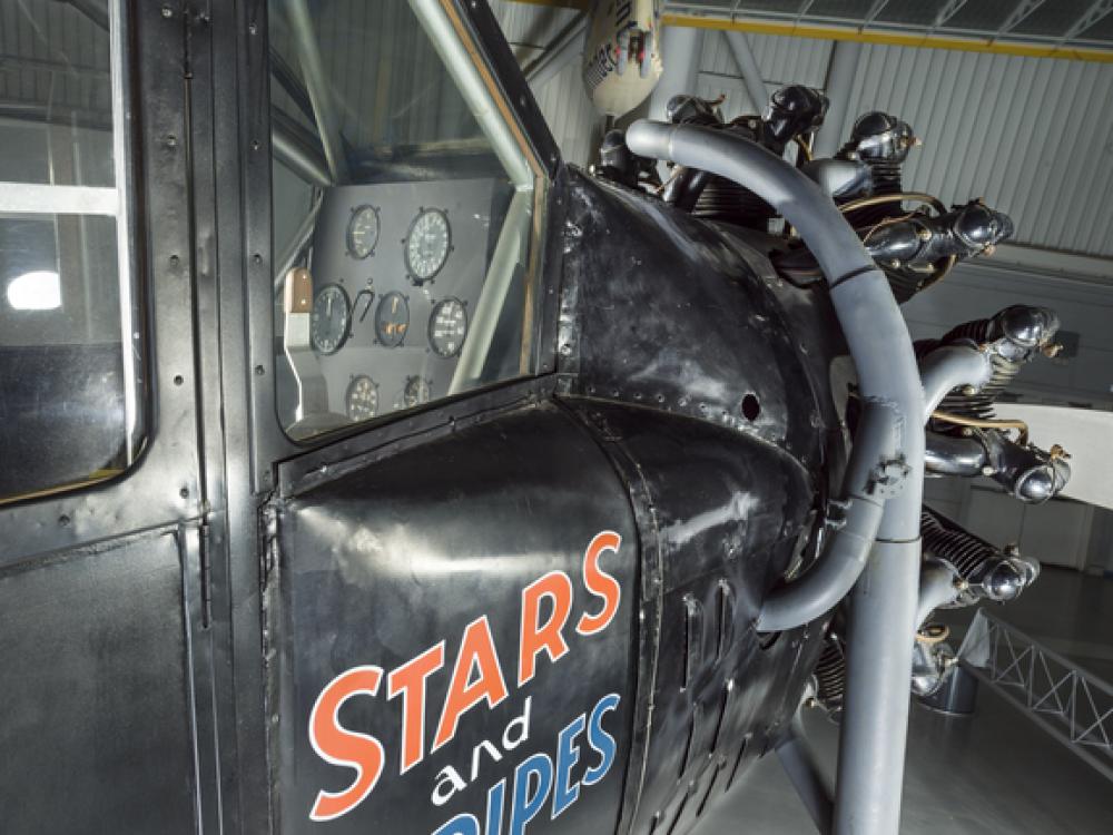 View of the cockpit and engine of an airplane. The words Stars and Stripes are painted on the side of the airplane.