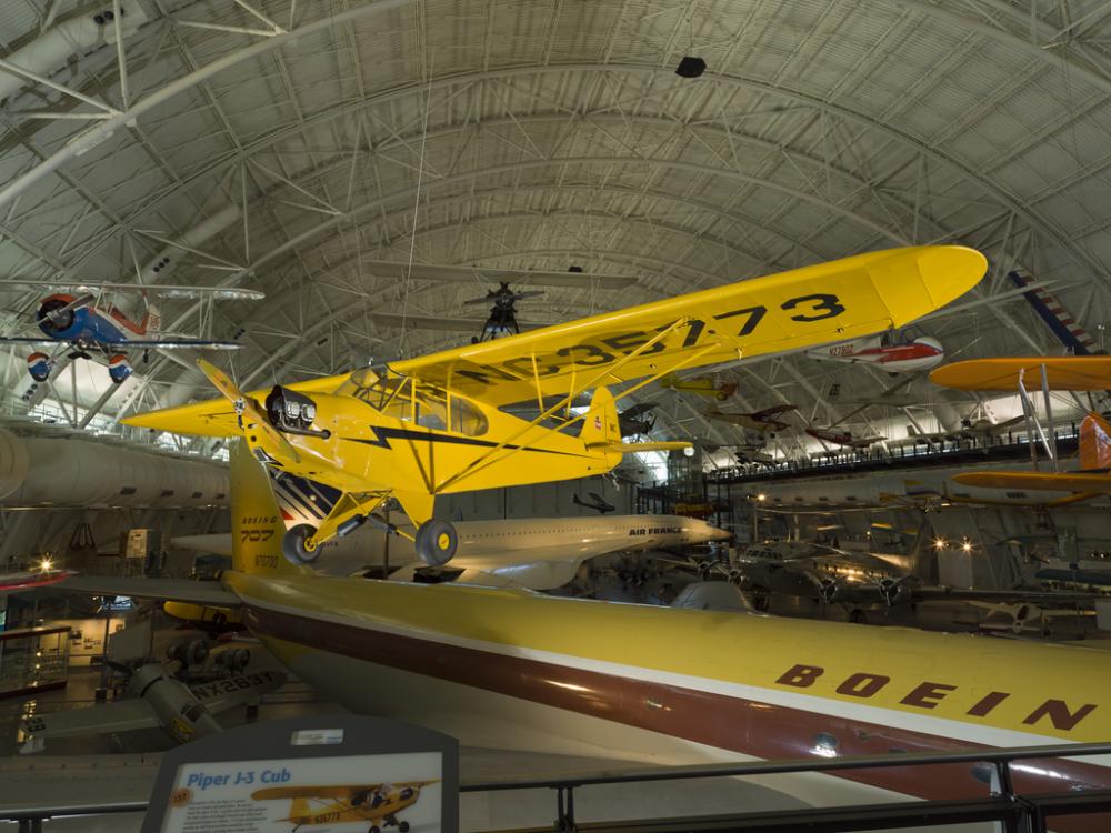 Yellow biplane hanging in the museum.