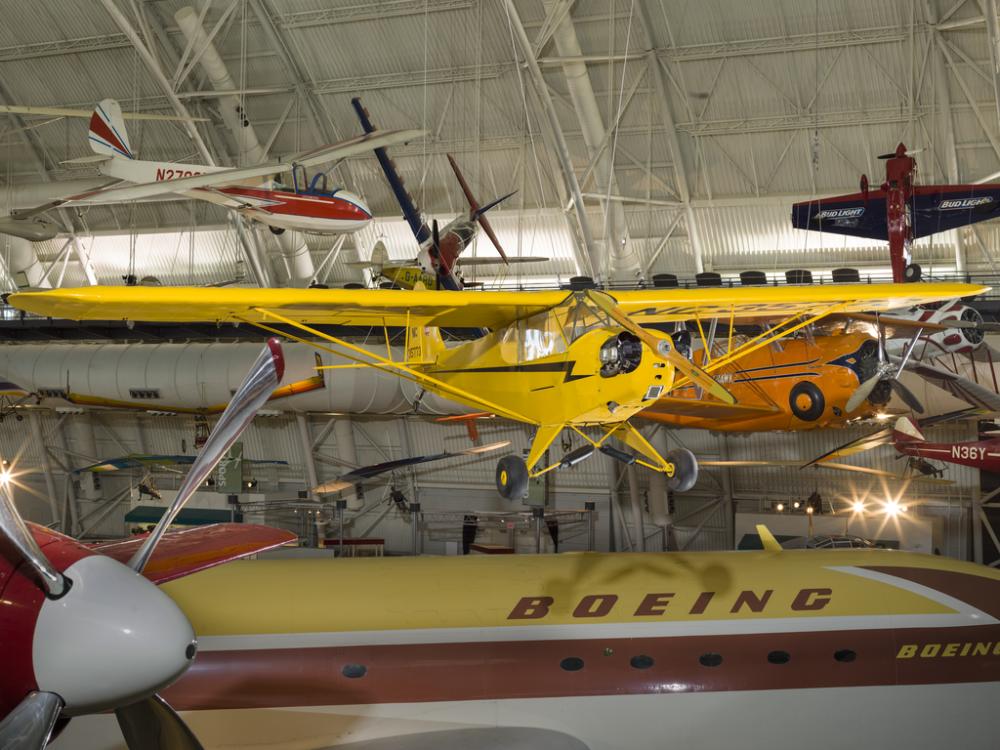 Yellow painted bi-plane hanging in the museum. 