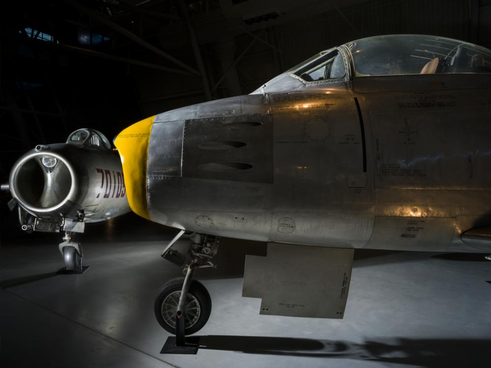 Nose of airplane with a second airplane in the background. 