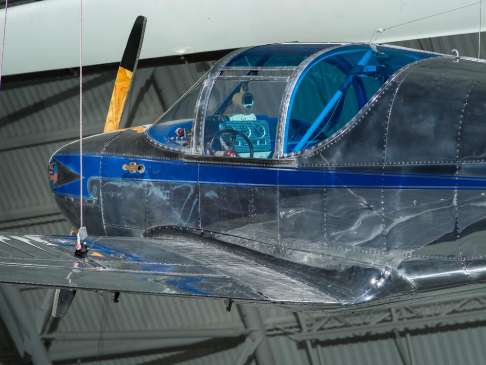 Cockpit and propellers of a aircraft. The cockpit has windows that are blue tinted. 