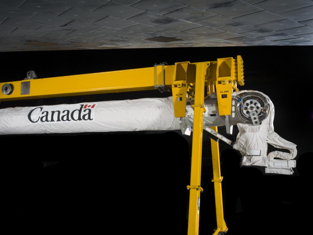 A robotic arm attached to a support beam. 