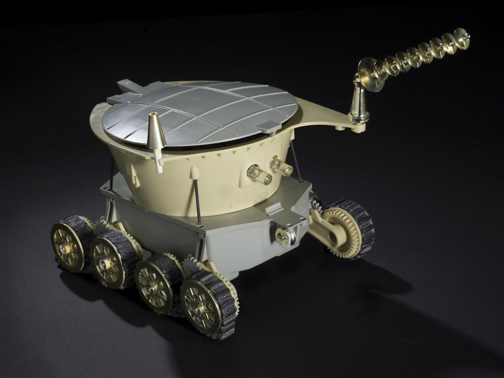 A motorized toy with cone-shaped antenna and six wheels. 