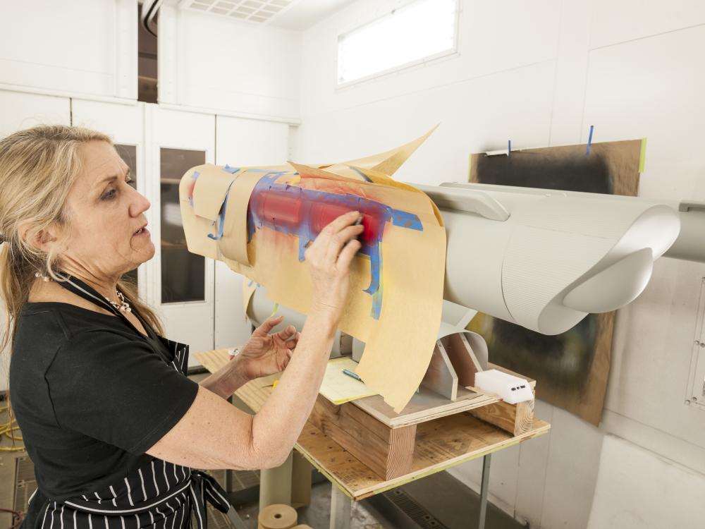 Kim adds red paint to the model's nacelles. 