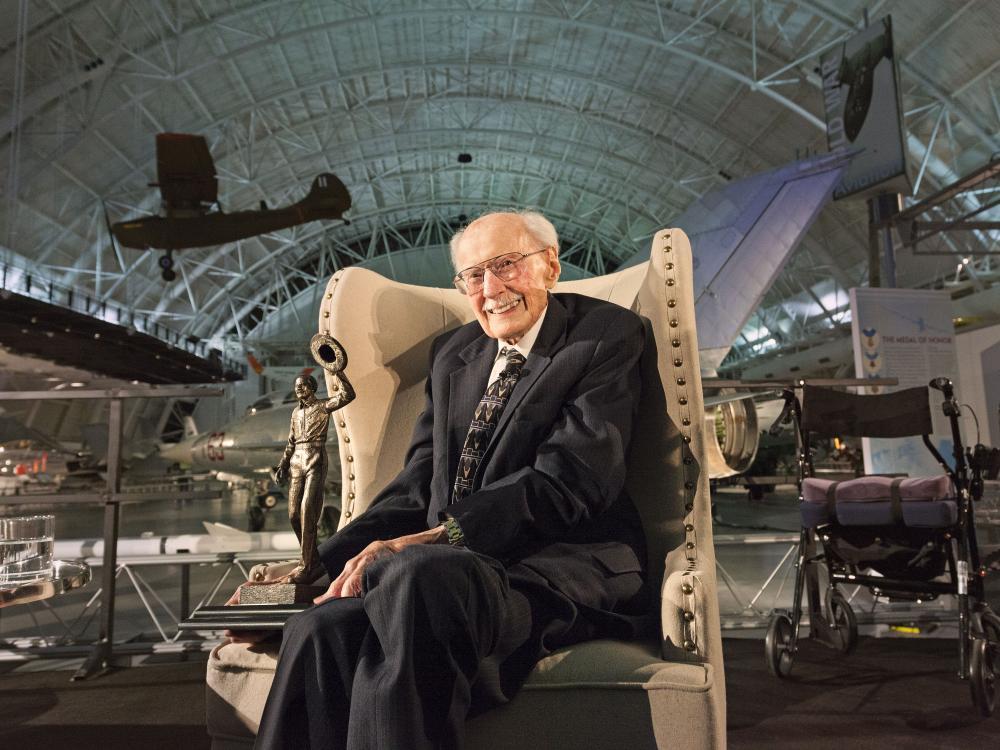 Bob Hoover sitting in a chair amongst the exhibitions at the Udvar-Hazy Center. 