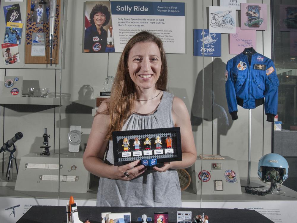 Maia Weinstock with her LEGO® set in front of a Sally Ride display case at the Smithsonian’s National Air and Space Museum in Washington DC.