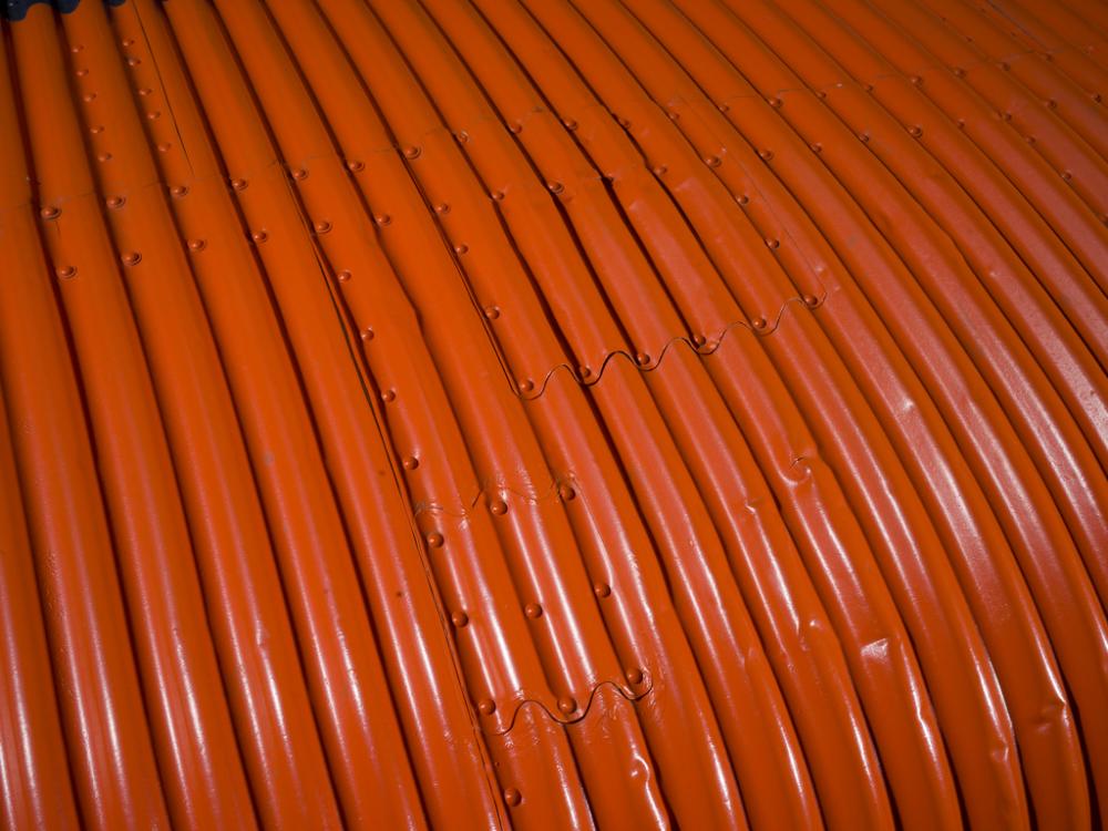 Close up image of an orange wing of a plane.