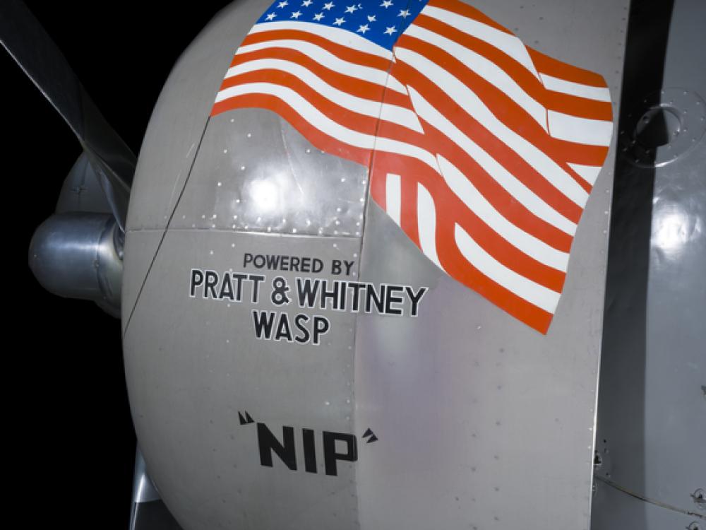 View of an engine with an American flag logo on an airplane. 