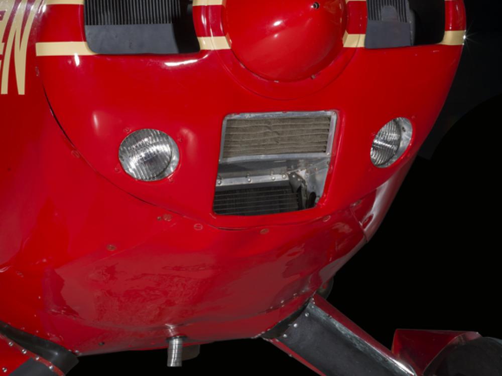 Close up of the nose of a red pained plane. 