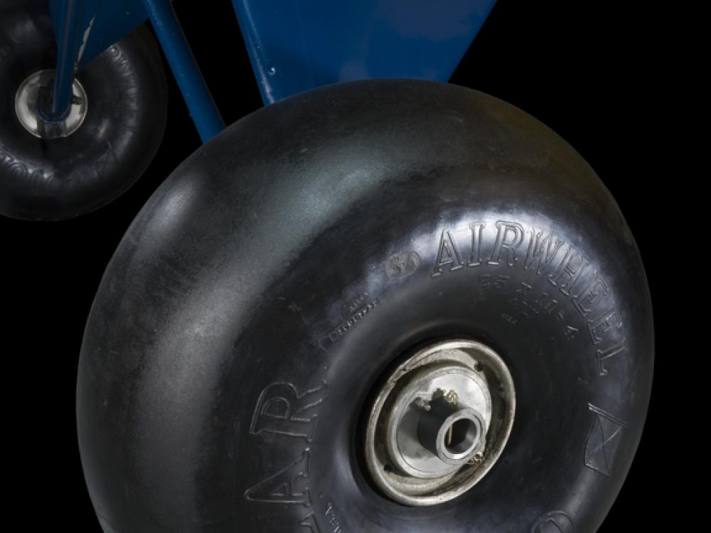 Close of of a tire and blue painted landing gear of a airplane. 