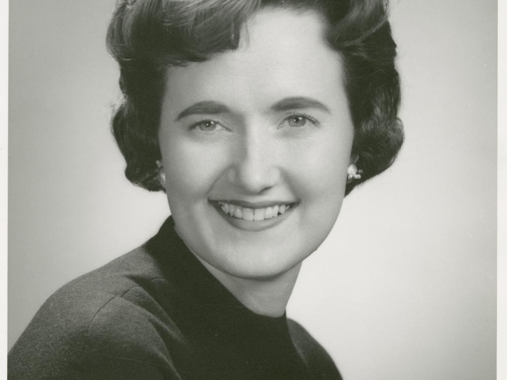 Black and white portrait of a woman smiling.