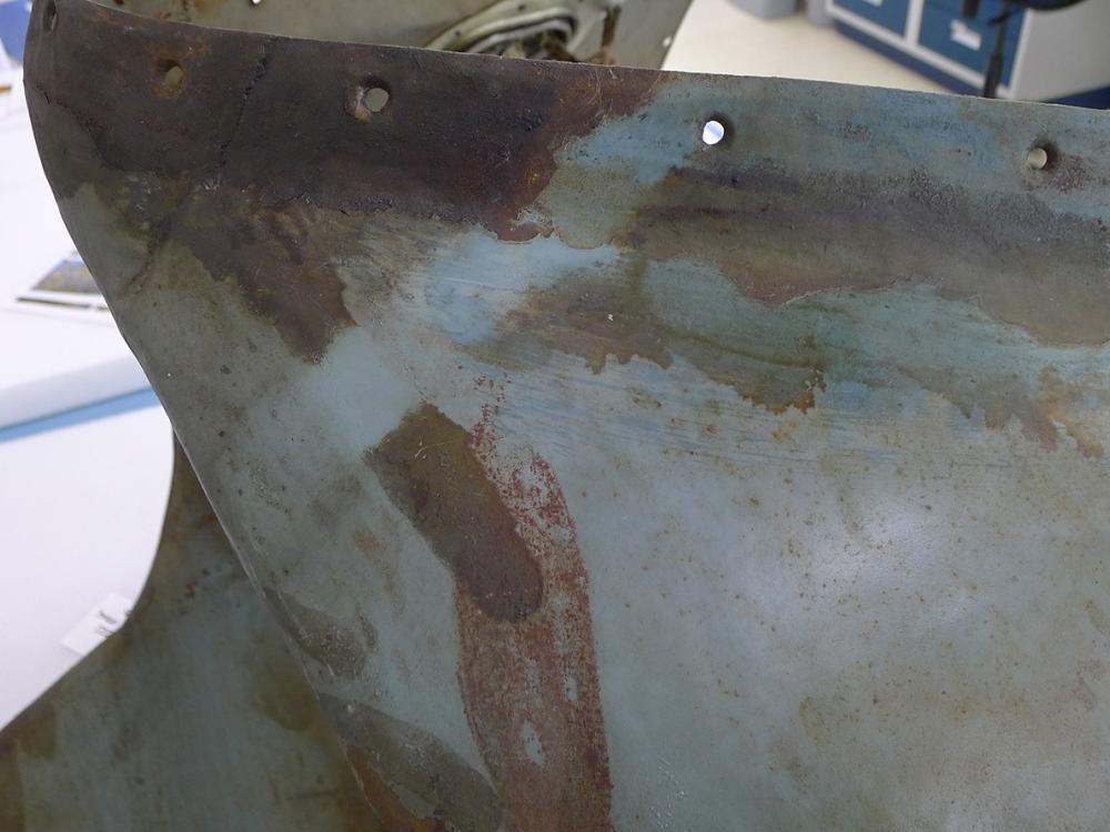 A section of the Horten Ho 229 V3 is tested to determine if a certain cleaning method will move a preservative coating. In this instance, a small strip of the section of the gray monoplane is significantly cleaner than before.