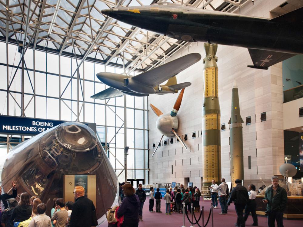 A large wind tunnel fan previously used by NASA hangs on a wall of the Museum's Washington, D.C. building alongside other museum objects.