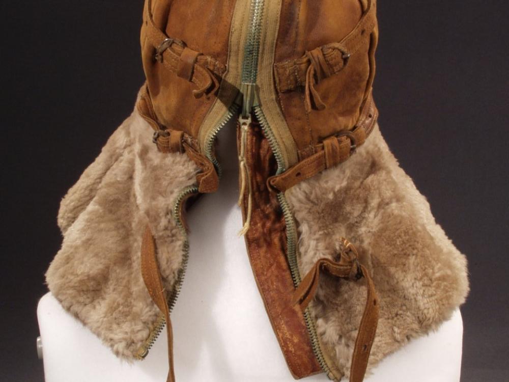 Back view of aviation helmet with leather faceguard and cap and brown fur collar protecting the neck. A full-length zipper and adjustment straps allow for a proper fit. Styled on mannequin.