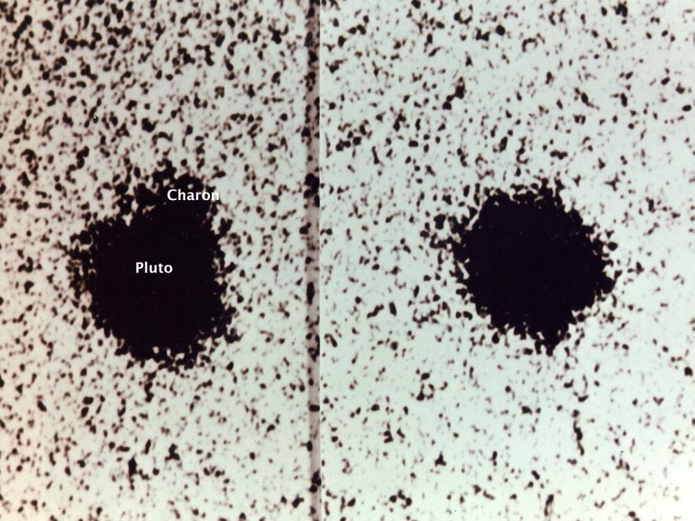 Telescopic view of Pluto and one of its moons, Charon. This was taken at the first discovery of Charon, which is visible as a tiny dot with its name labeled under the view.