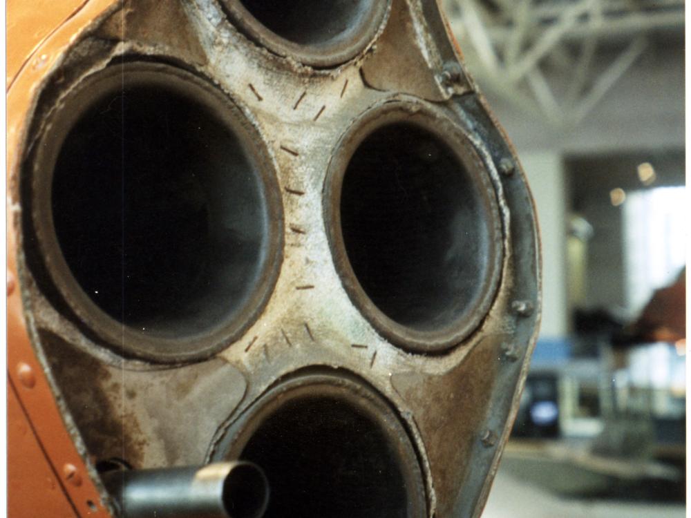 Front of four-rocket engine of orange military monoplane.