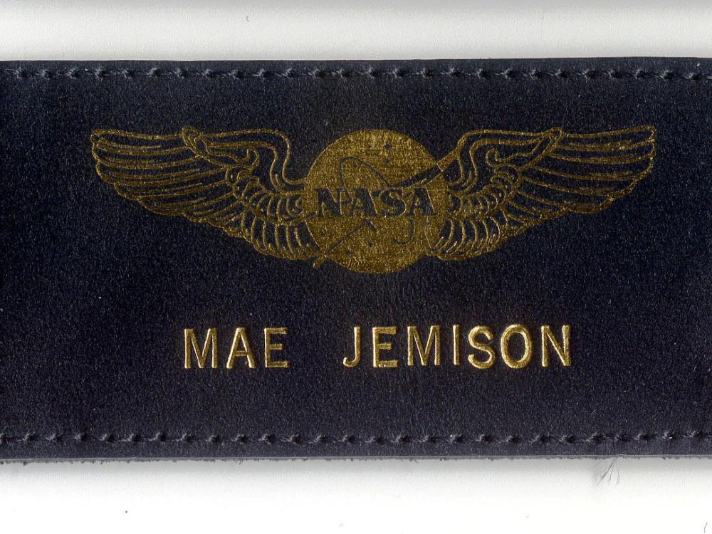 Black leather name tag with name "Mae Jemison" below NASA emblem with wings. The name and emblem are embossed in a golden color.