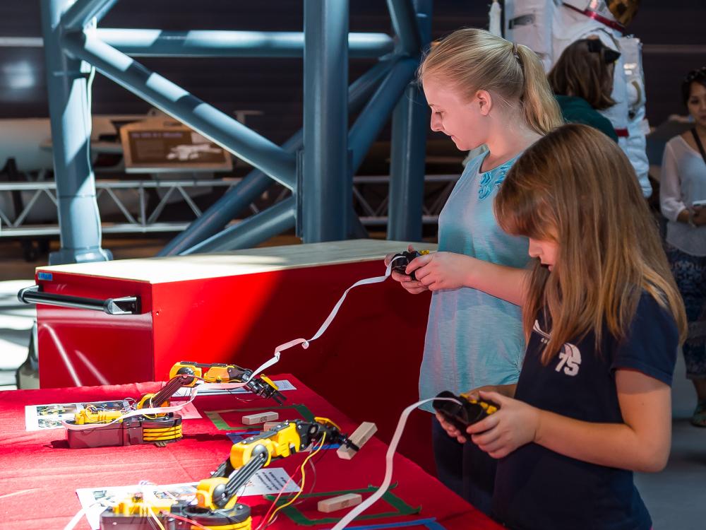 Two museum visitors participate in a robot activity as part of an astronaut game at the Museum's Steven F. Udvar-Hazy Center.