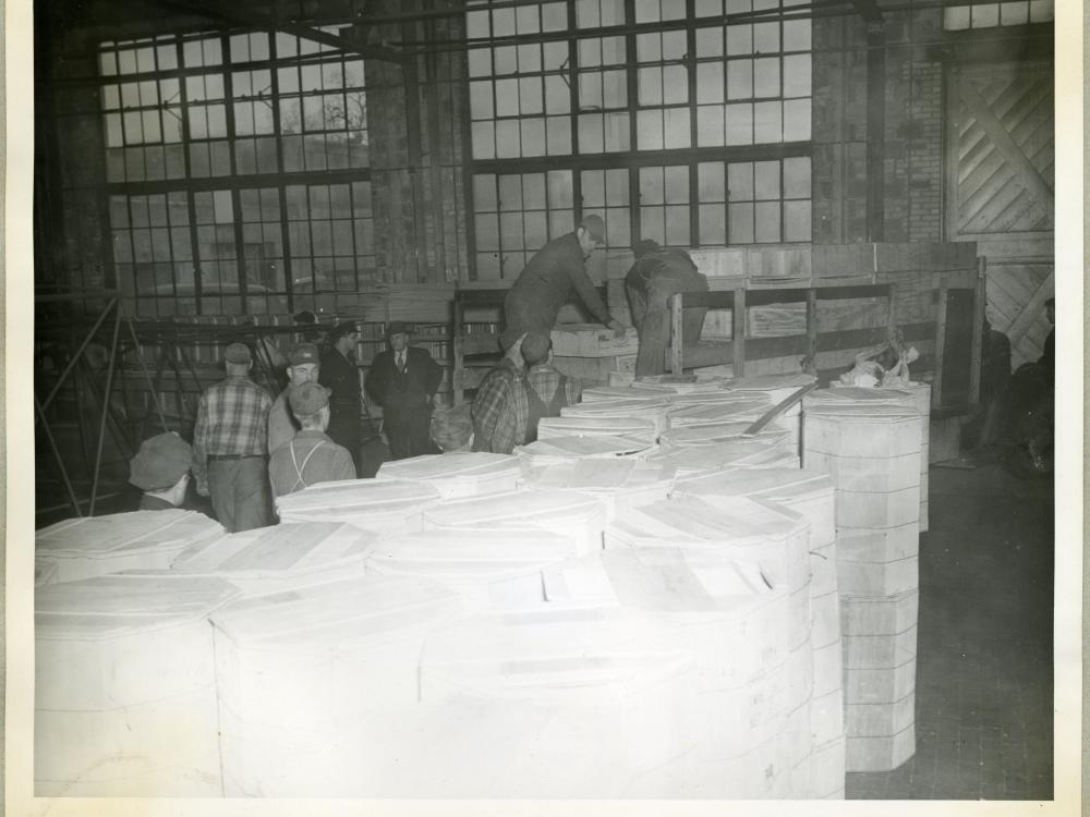 A group of men employed with the Northwestern Aeronautical Corporation unload cases of turkeys prior to a holiday giveaway to employees.