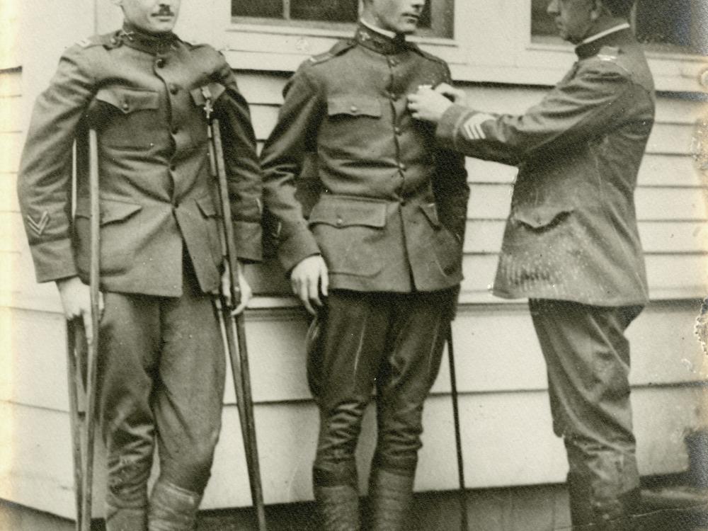 A male second lieutenant receives a service medal. The lieutenant is injured and using a cane.