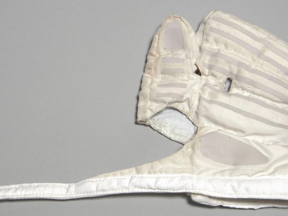 Left-handed white overglove in flat position. Part of stratospheric spacesuit.