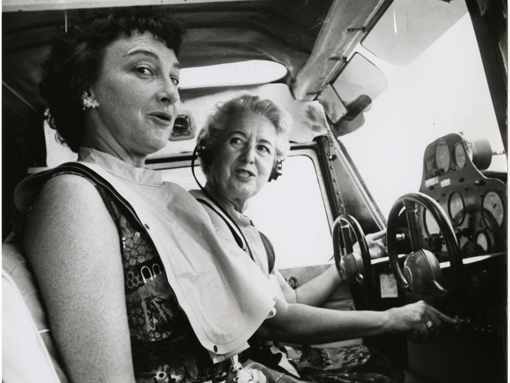 Two women, pilot Edna Whyte and her student, Martha Wright, sit in the cockpit of an aircraft during an air race.