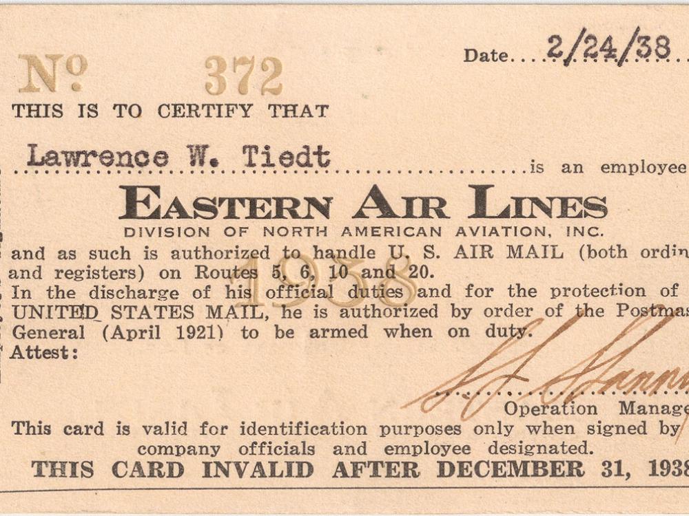 A rectangular identification card with a spot for a person's name up top and a description underneath granting the holder certain authority as related to air mail. 