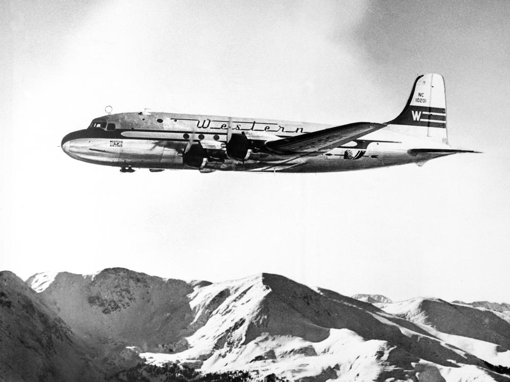 Side view of commercial aircraft in flight. Aircraft features Western Airlines livery.