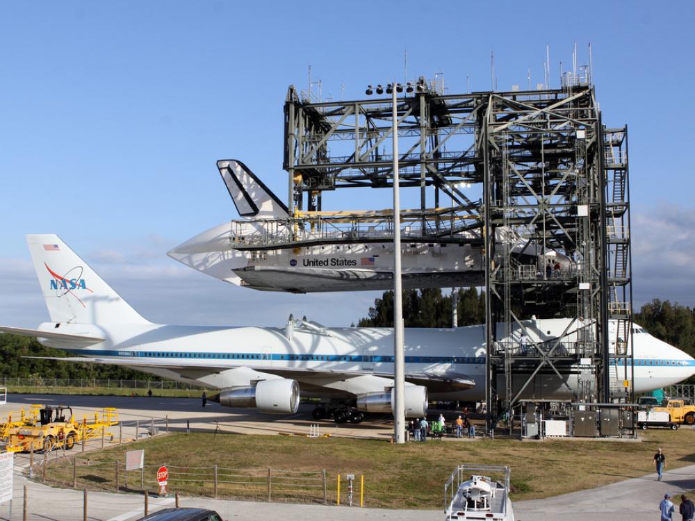 The Space Shuttle Discovery is lifted and ready to be placed on top of an aircraft designed to carry space shuttles.