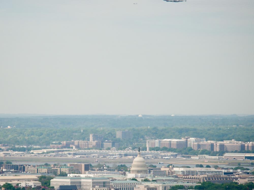 The Space Shuttle Discovery, attached to an aircraft modified for transporting shuttles, flies over the United States Capitol.