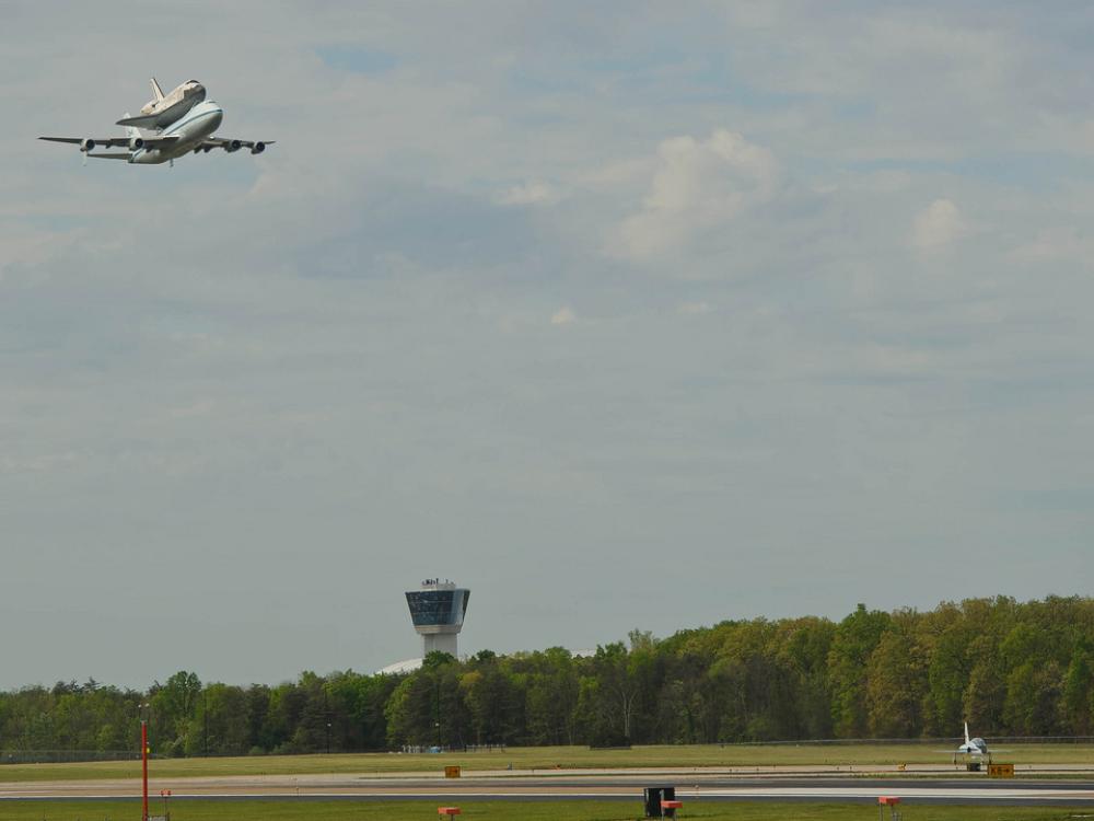 The Space Shuttle Discovery, attached to an aircraft modified for transporting shuttles, flies above Washington-Dulles airport prior to landing.