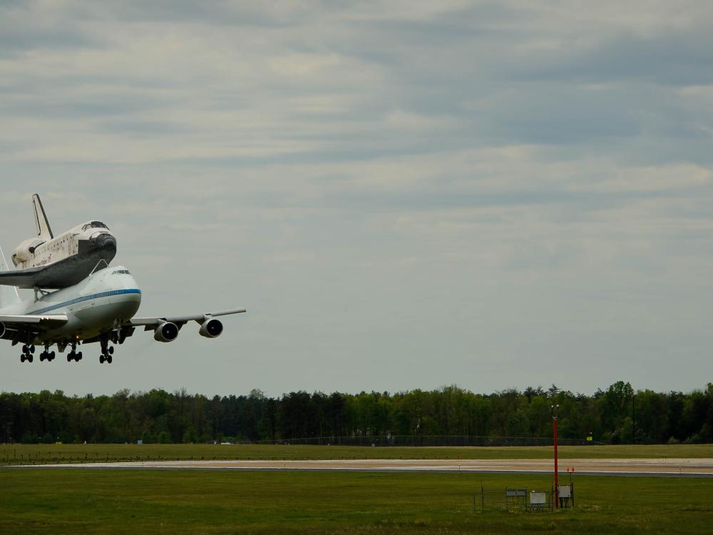 Space Shuttle Discovery, attached to an aircraft modified for shuttle transport, lands at Washington Dulles International Airport.