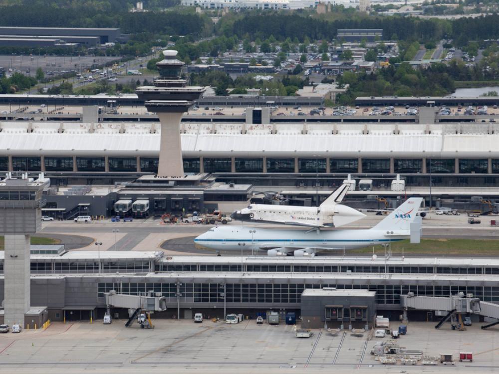 Space Shuttle Discovery, attached to an aircraft modified for shuttle transport, taxis on the runway at Washington Dulles International Airport.