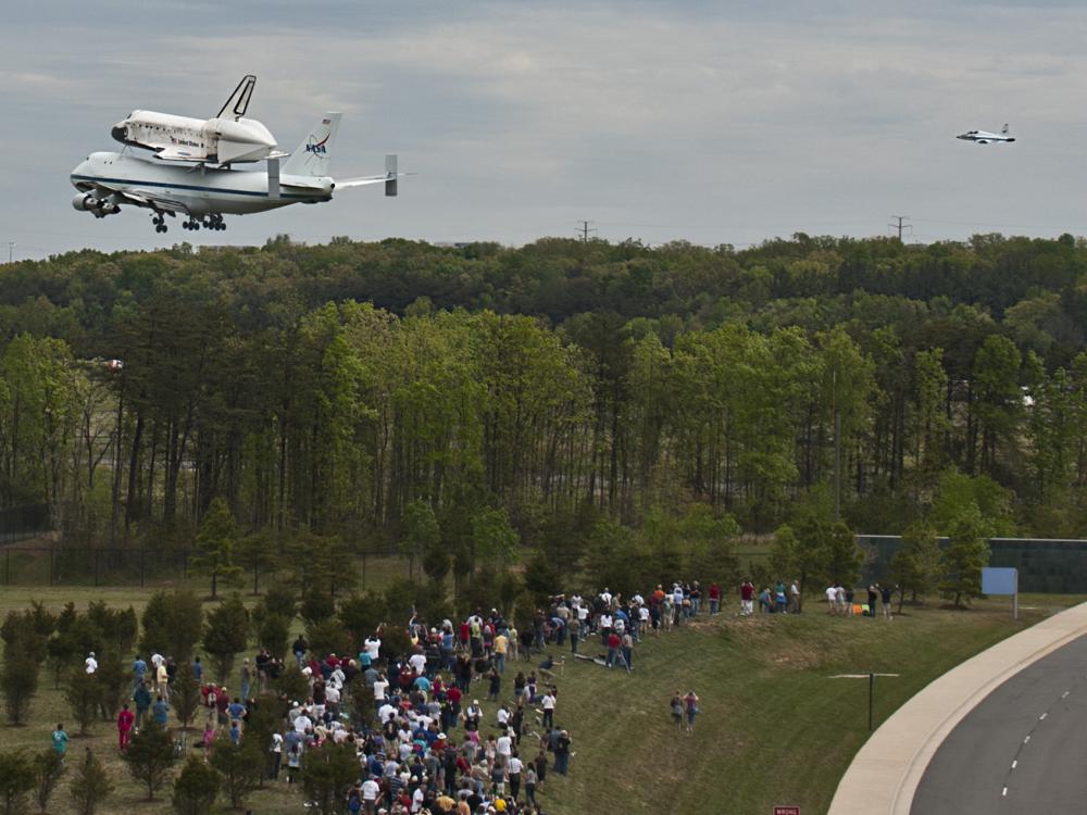 Space Shuttle Discovery flies low over crowd