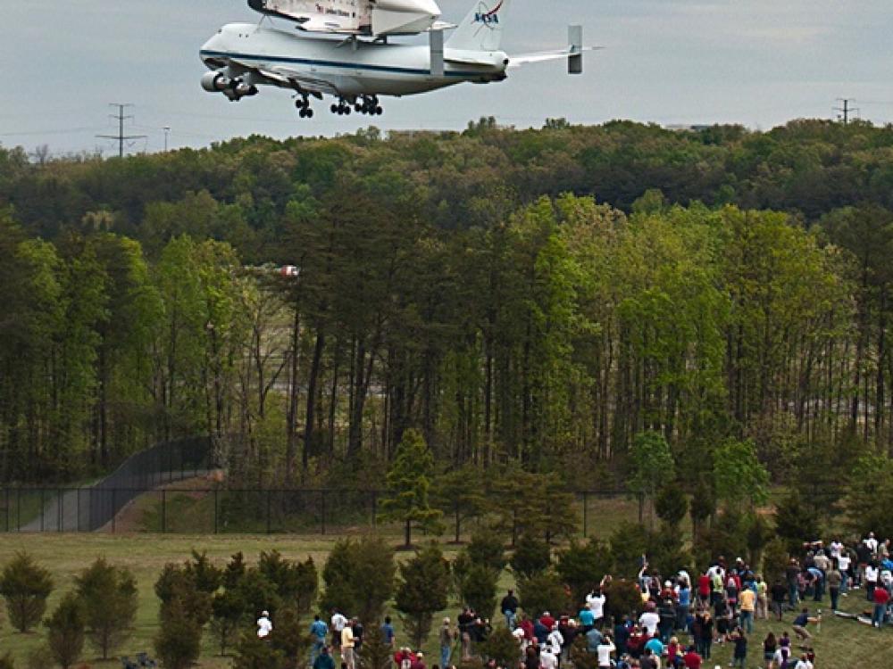 Space Shuttle Discovery flies low over crowd