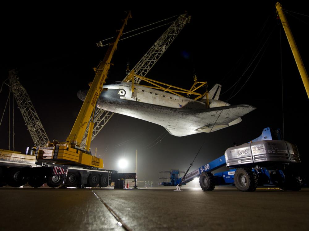 The Space Shuttle Discovery is lifted on a crane following its deattachment from the modified Boeing 747 used for shuttle transport.