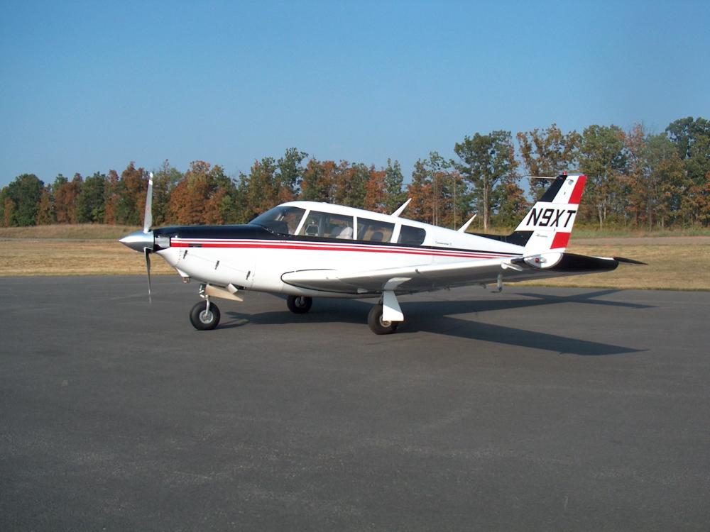 Side view of a white aircraft with one propellor attached to the nose. The registration number N9XT is painted on the vertical stabilizer.