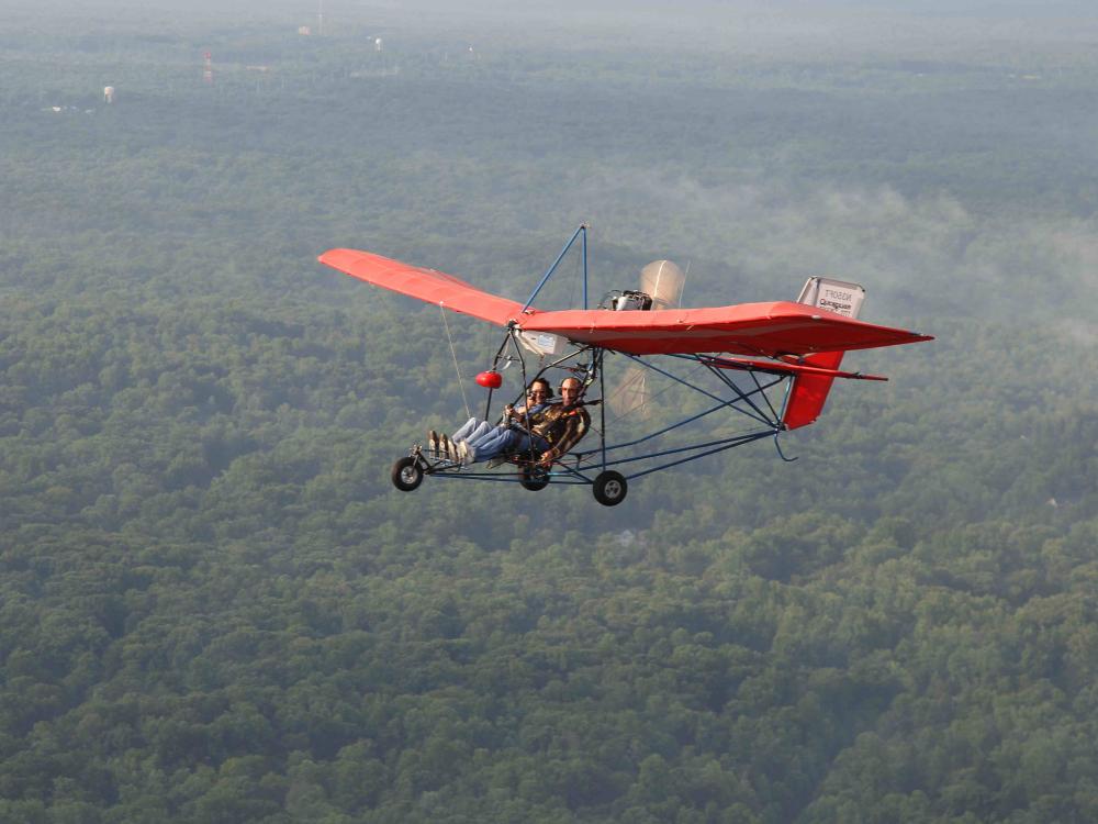 Red-winged ultralight aircraft with seating for two people.