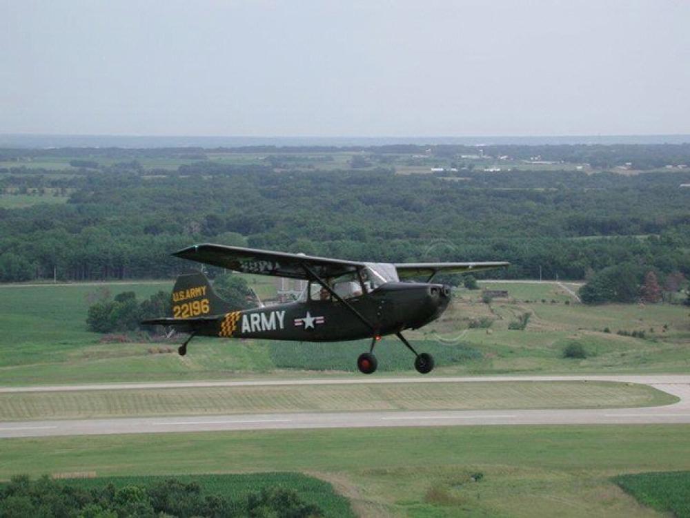 Side view of a gray monoplane in flight. White and yellow markings mark the plane as having belonged to the U.S. Army. The registration number 22196 is painted in yellow on the visible side of the vertical stabilizer.