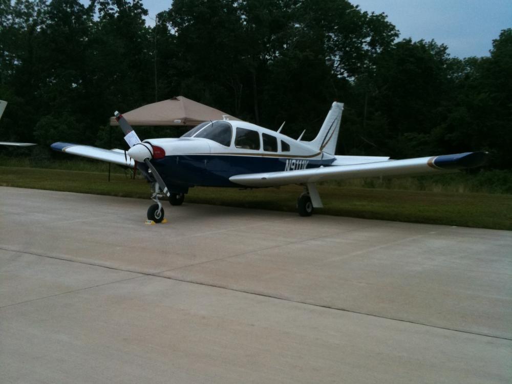 Frontal side view of a white and blue airplane with one propellor attached to the nose.