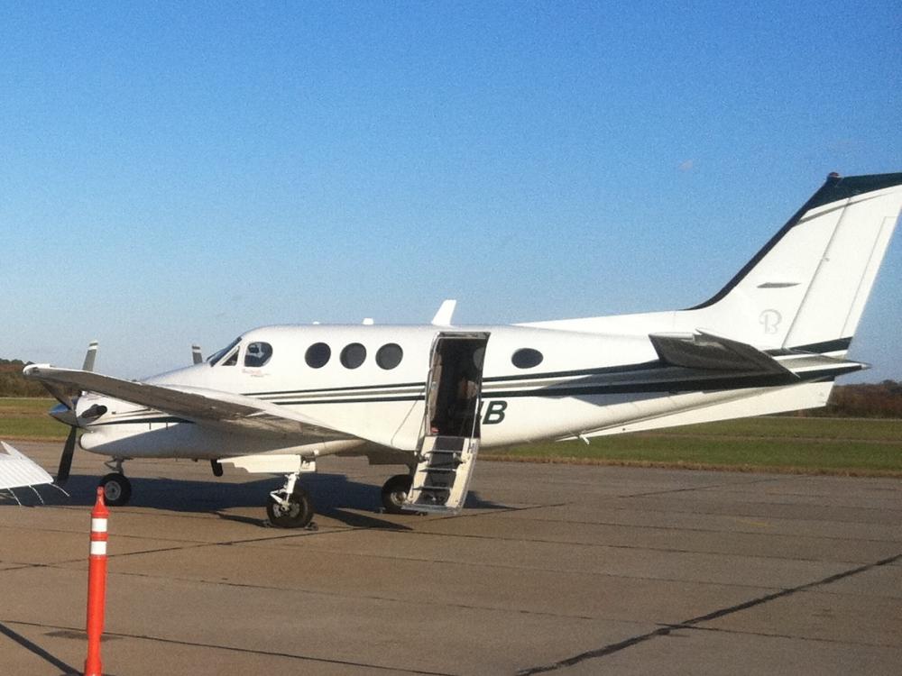 Side view of white aircraft with open door allowing interior access in the middle of the fuselage.