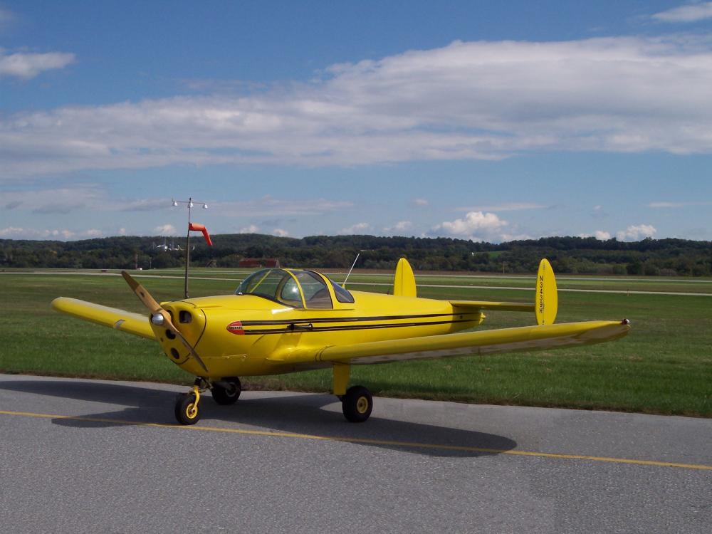 Side view of yellow monoplane with single engine.