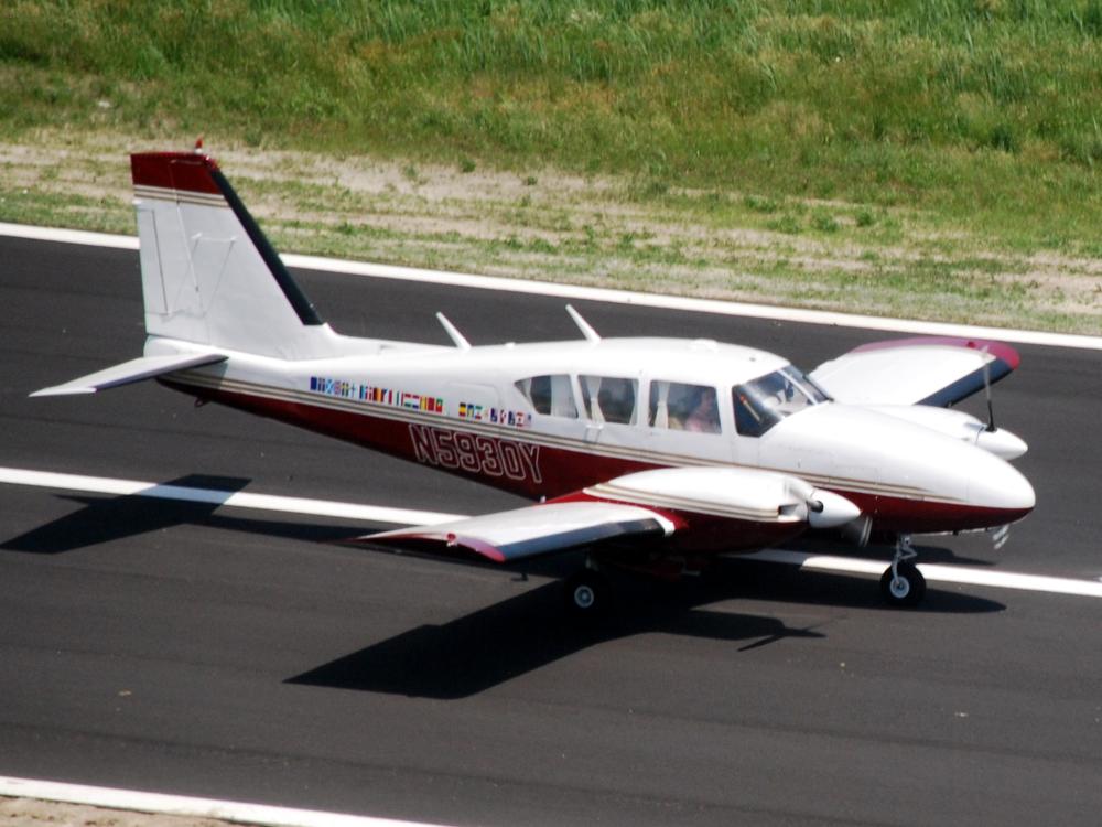 Side view of white and red monoplane with twin engines.