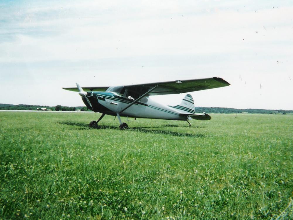 Side view of white monoplane with single engine.