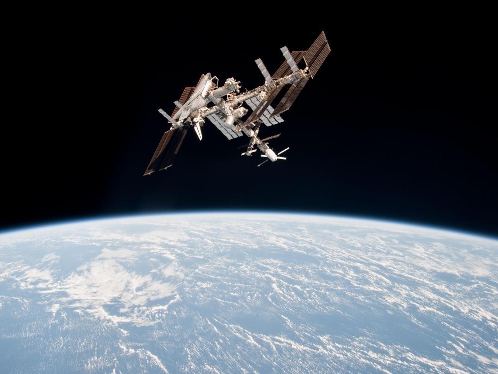 The Space Shuttle Endeavour is docked onto the International Space Station above Earth.