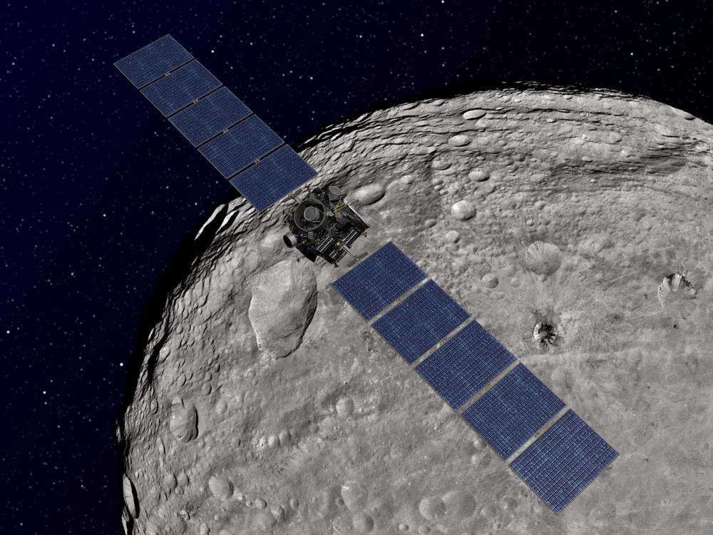 An artist's rendering of a spacecraft with very long sets of solar panels compared to the body of the spacecraft orbiting an asteroid.